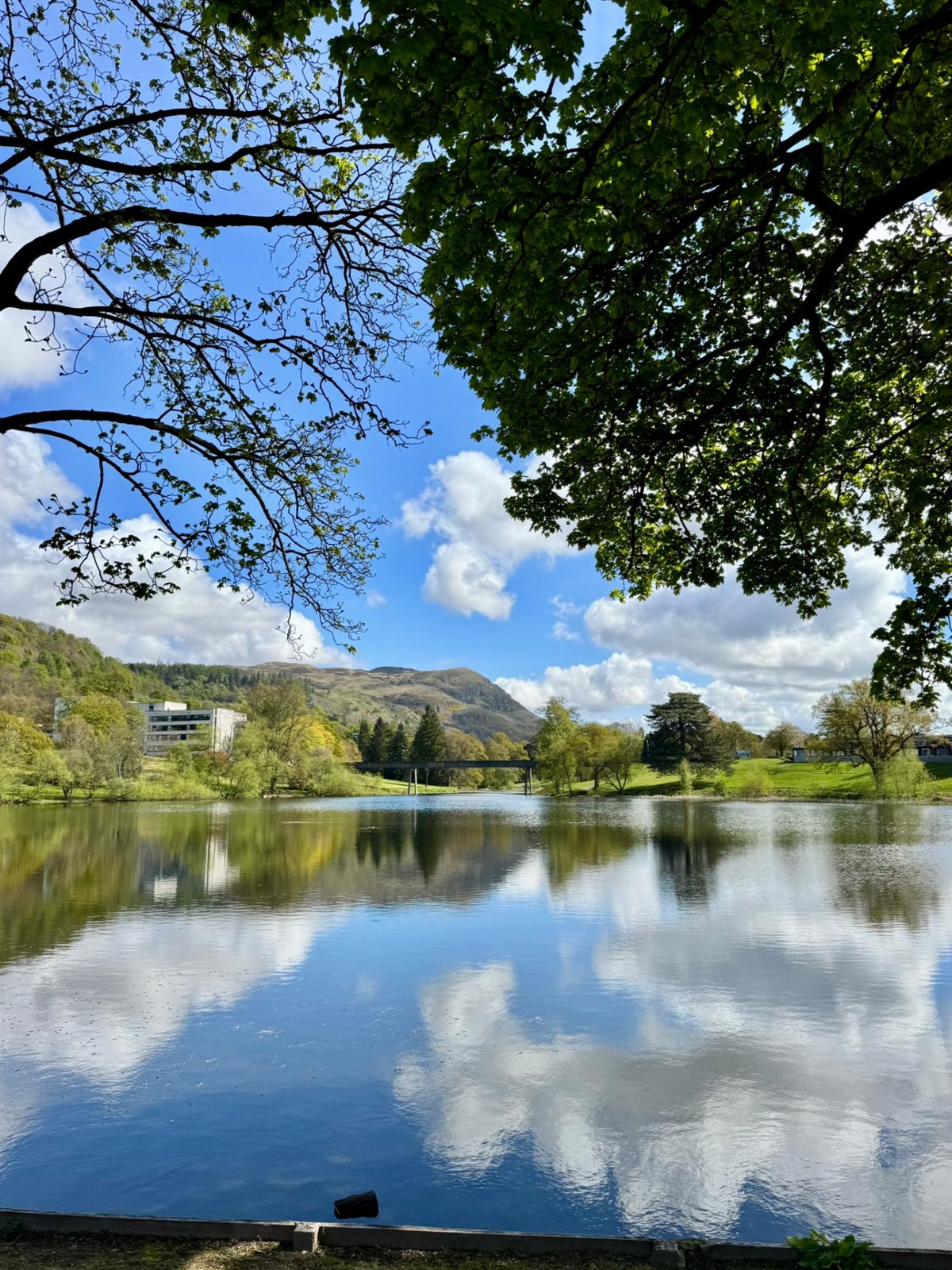 Airthrey Loch on the University of Stirling campus, reflecting trees and hills